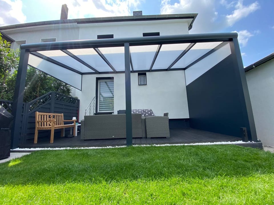 Terrassendach in Anthrazit mit Glasdach über einer Lounge-Terrasse am Einfamilienhaus